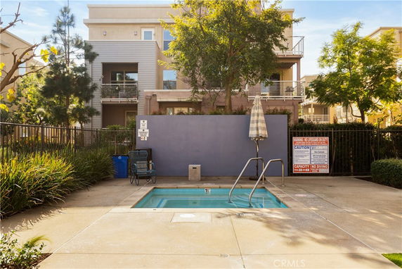 Small outdoor swimming pool with a safety fence in a residential area.