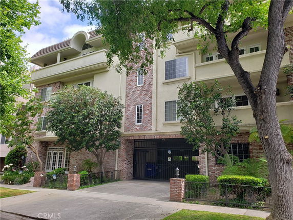 Front view of a multi-story building with brick and stucco facade.