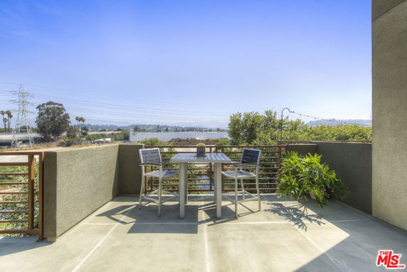 Balcony area with outdoor seating and view of the surrounding landscape.