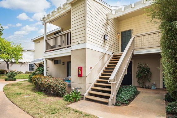 Front view of a two-story residential building with exterior stairs leading to the upper floor.