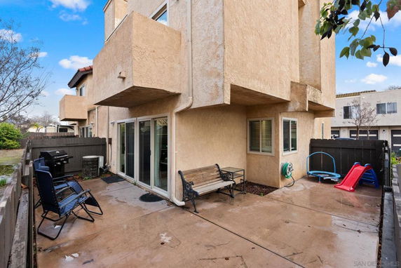 Rear view of a multi-story building with a patio area.