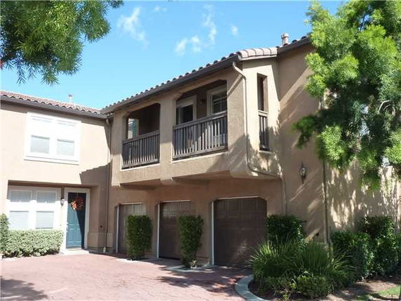 Front view of a two-story house with a garage and balcony.