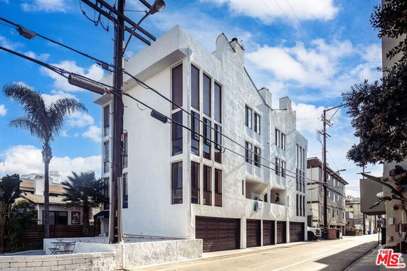 Front view of a multi-story building with multiple garage doors.