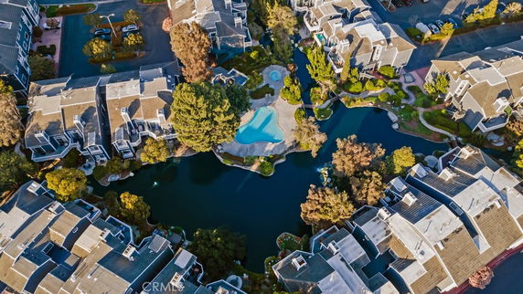 Aerial view of residential buildings surrounding a central pool and landscaped areas.