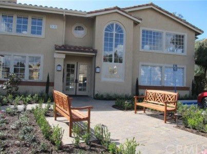 Front view of a two-story house with large windows and a landscaped entrance.