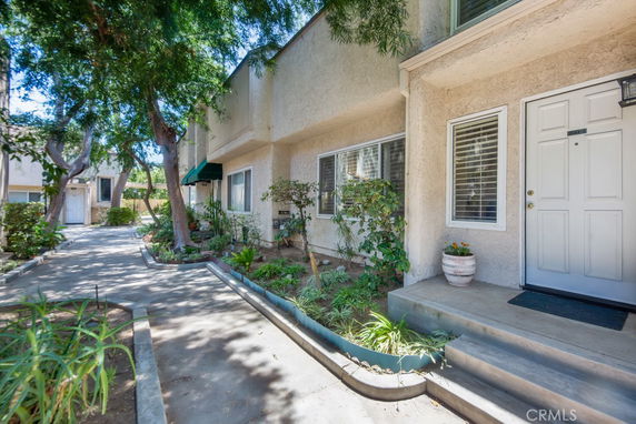 Front view of a residential building with a pathway and plants.
