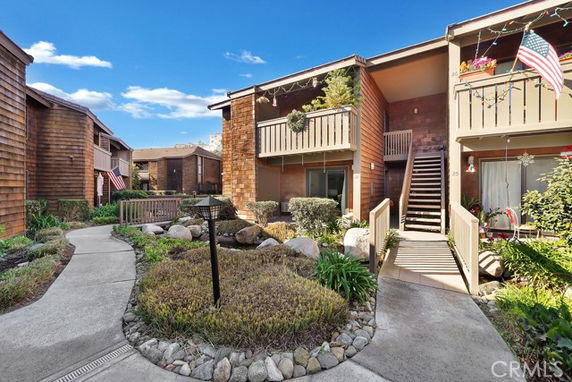 View of a two-story apartment complex with balconies and a central walkway.