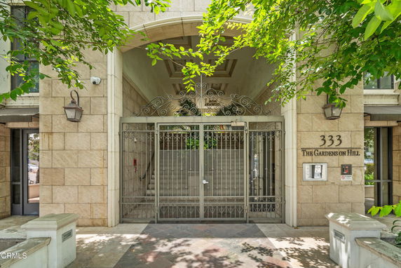 Front view of a building entrance with a gated entry and stone facade.
