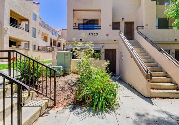 Front view of a multi-story residential building with exterior stairs.