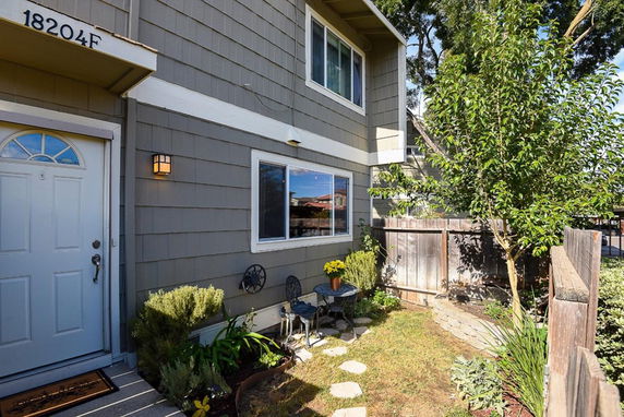Front view of a two-story house with a garden area.