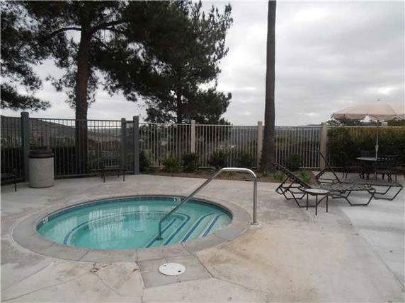 Outdoor area featuring a round hot tub with surrounding lounge chairs.