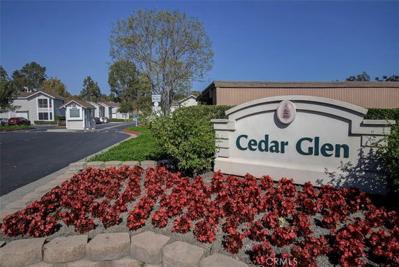 Front view of residential buildings with a sign reading 'Cedar Glen' in the foreground.