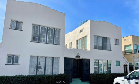 Front view of a two-story building with multiple windows and a gated entrance.