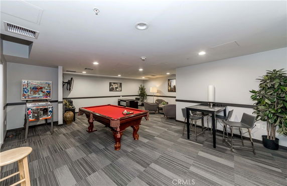 Interior view of a recreation room with a pool table and seating area.