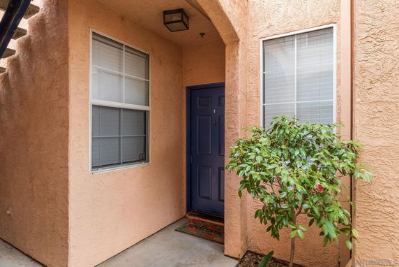 Entrance area of a building with a blue door and windows.