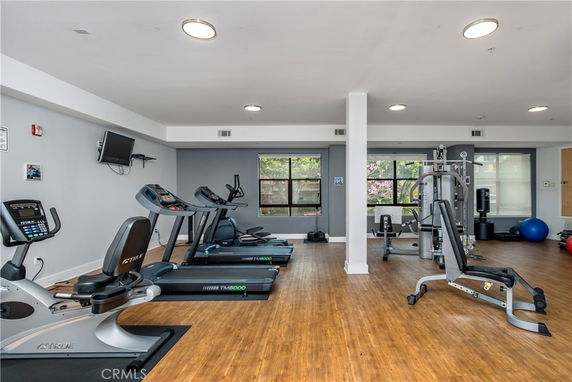 Indoor gym area with exercise equipment and large windows.