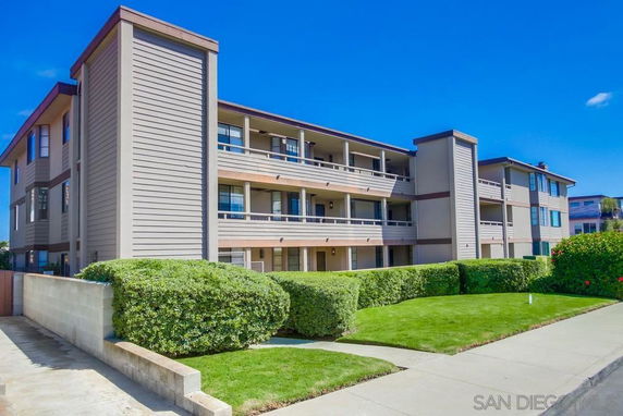 Front view of a three-story apartment building with balconies.