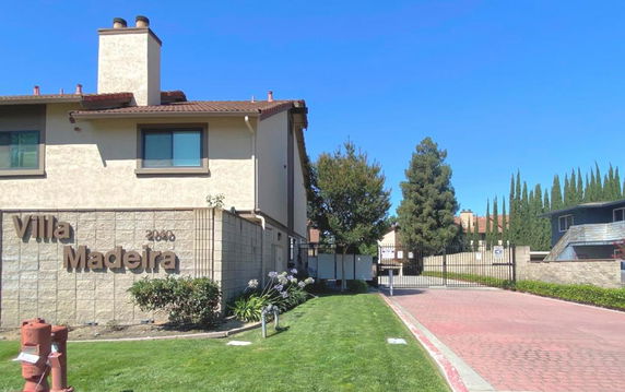 Front view of a building with a sign reading 'Villa Madeira' and a gated entrance.