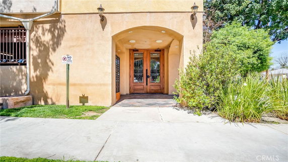 Front view of a building entrance with wooden double doors.
