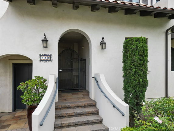 Front entrance of a house with an arched doorway and steps leading up.
