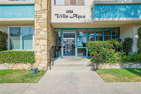 Front view of a building with stone and glass entrance labeled 'Villa Aqua'.