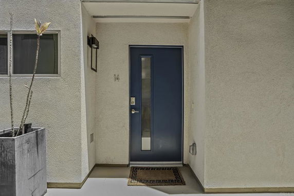 Front view of a house entrance with a blue door and small window.