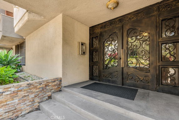 Front view of a building entrance with ornate metal doors and stone accents.