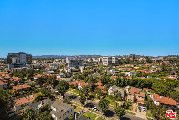 Panoramic view of a cityscape with residential and commercial buildings.
