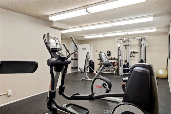 Indoor gym area with exercise equipment and machines.