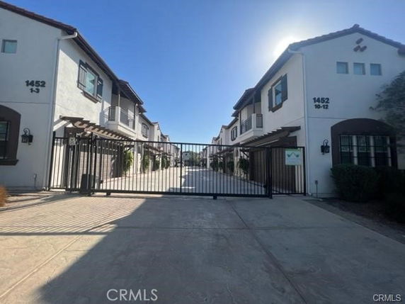 Front view of a gated residential building with two stories.