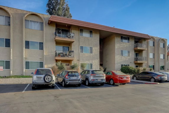 Front view of a multi-story apartment building with balconies.