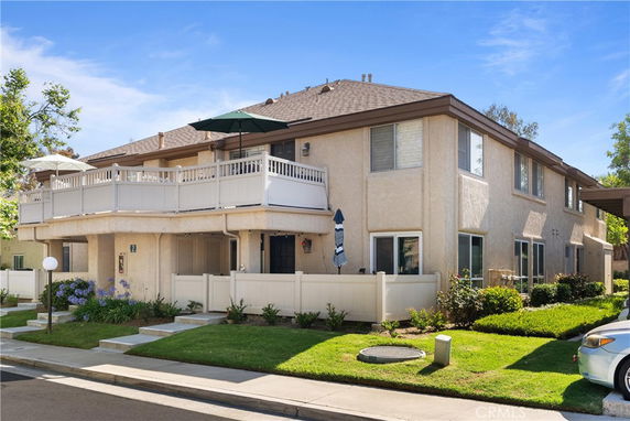 Front view of a two-story building with a large balcony and beige exterior.