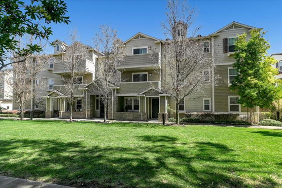 Front view of a multi-story residential building with balconies and entrances.