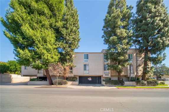 Front view of a multi-story building with trees in front.