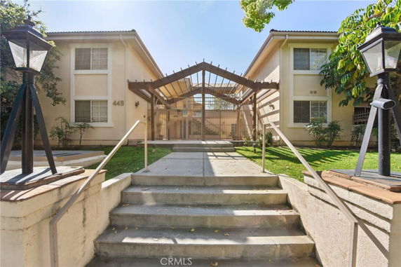 Front view of a two-story residential building with a central staircase and entrance canopy.