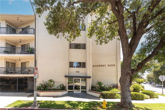 Front view of an apartment building with balconies and entrance.