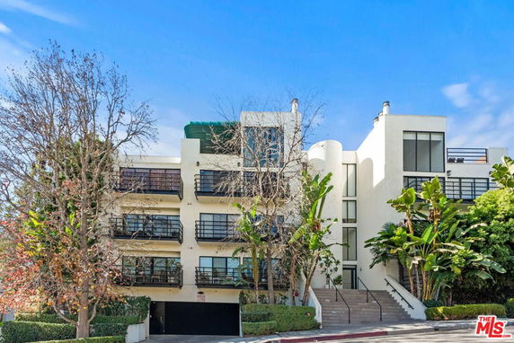 Front view of a multi-story apartment building with balconies and external staircases.