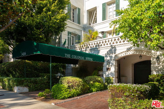 Front view of a multi-story colonial-style building with a green awning entrance.