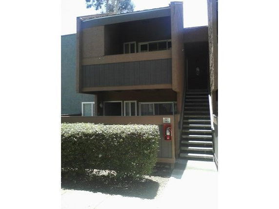 Front view of a two-story building with a staircase and balcony.