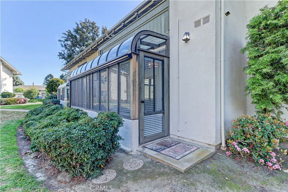 Front view of a building with a glass-enclosed porch entrance.