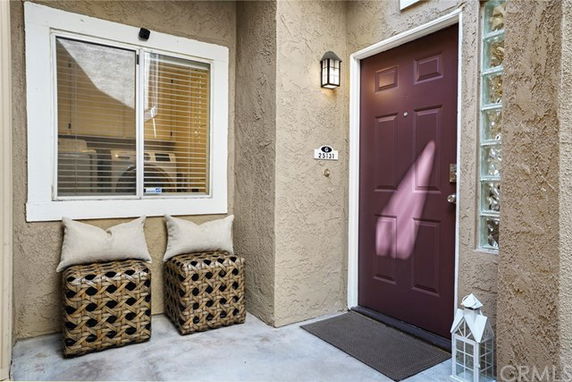 Front view of a residential entrance with a red door and a window.