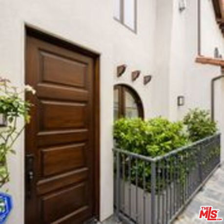 Front view of a house with a wooden door and iron railing.