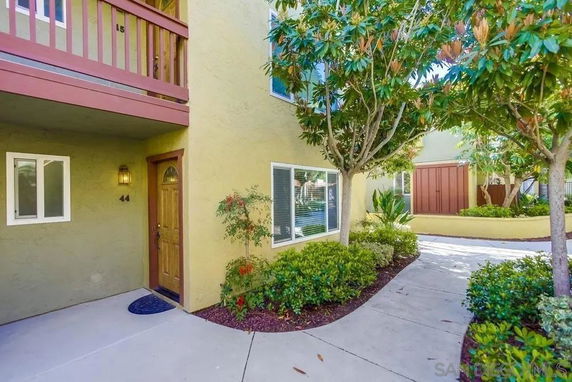Front view of a building with a wooden door and a small balcony.