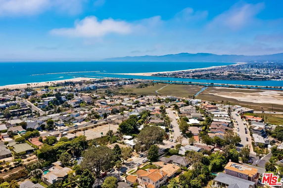 Panoramic view of a coastal residential area with houses and distant ocean.