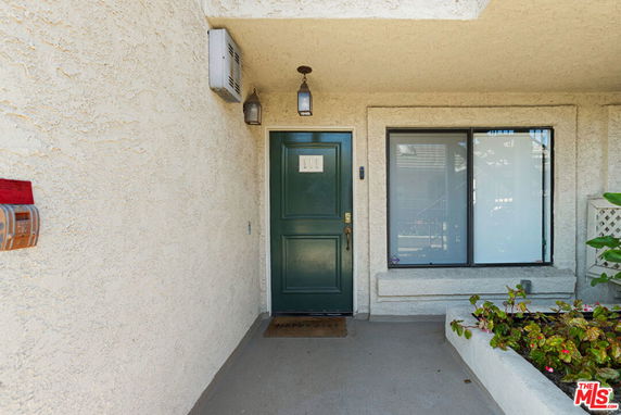 Front view of a building entrance with a green door and large window.