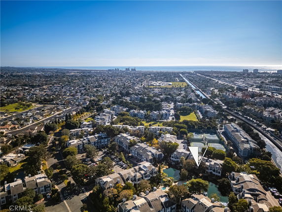 Panoramic view of a residential area with dense housing and distant cityscape near a body of water.