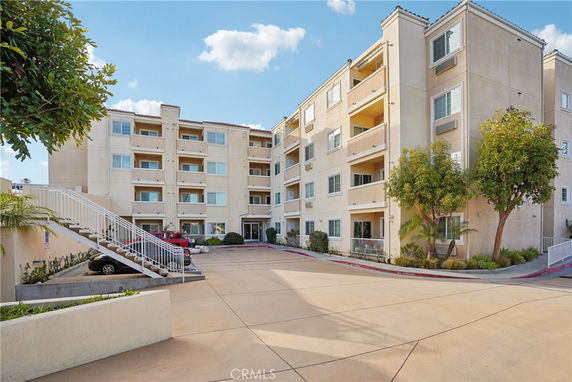 Front view of a multi-story apartment building with balconies.