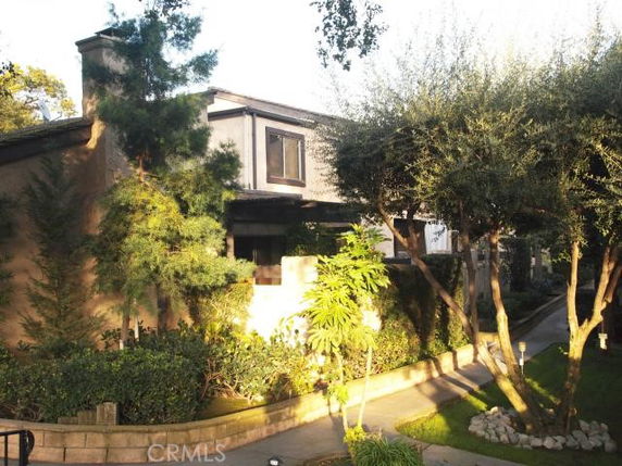Front view of a two-story house with trees and shrubs.