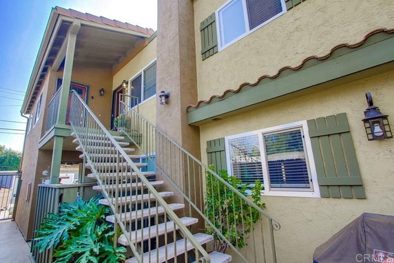 Front view of a two-story building with an external staircase leading to the upper floor.