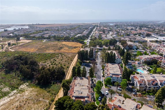 Aerial view of a residential area with houses and open land surrounding.